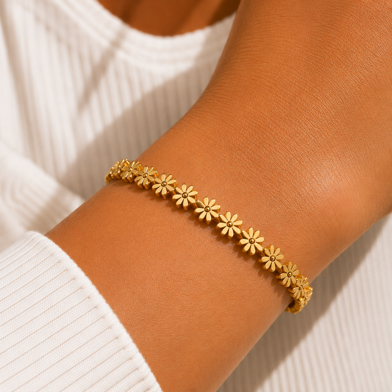 Gold bracelet with floral design on a white platform