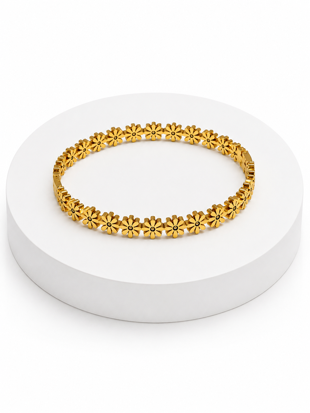 Gold bracelet with floral designs on a white platform