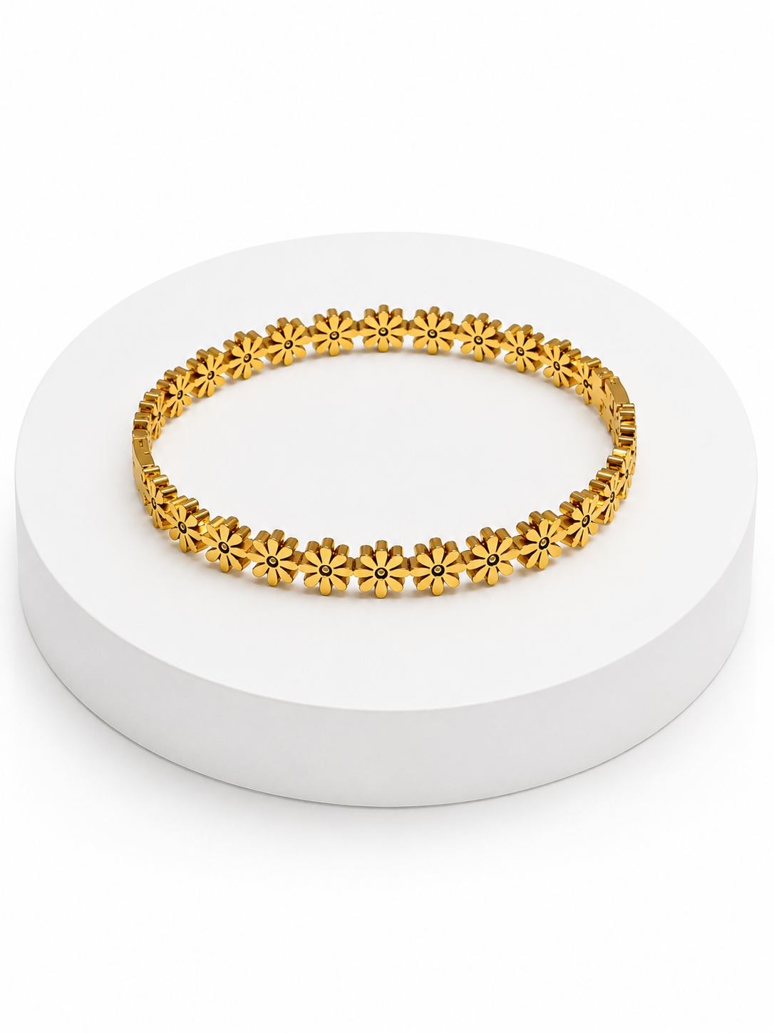 Gold bracelet with floral designs on a white platform