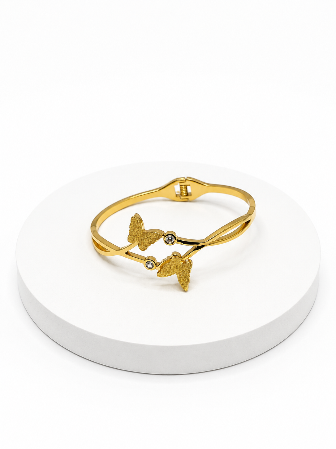Gold bracelet with butterfly designs on a white stand