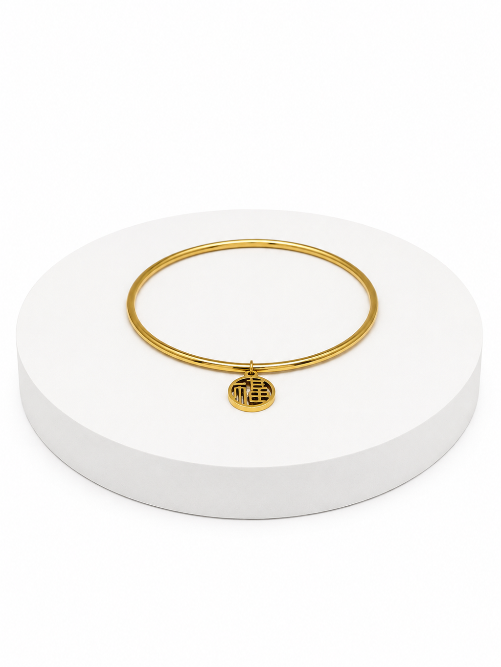 Gold bracelet on a white circular stand with a white background