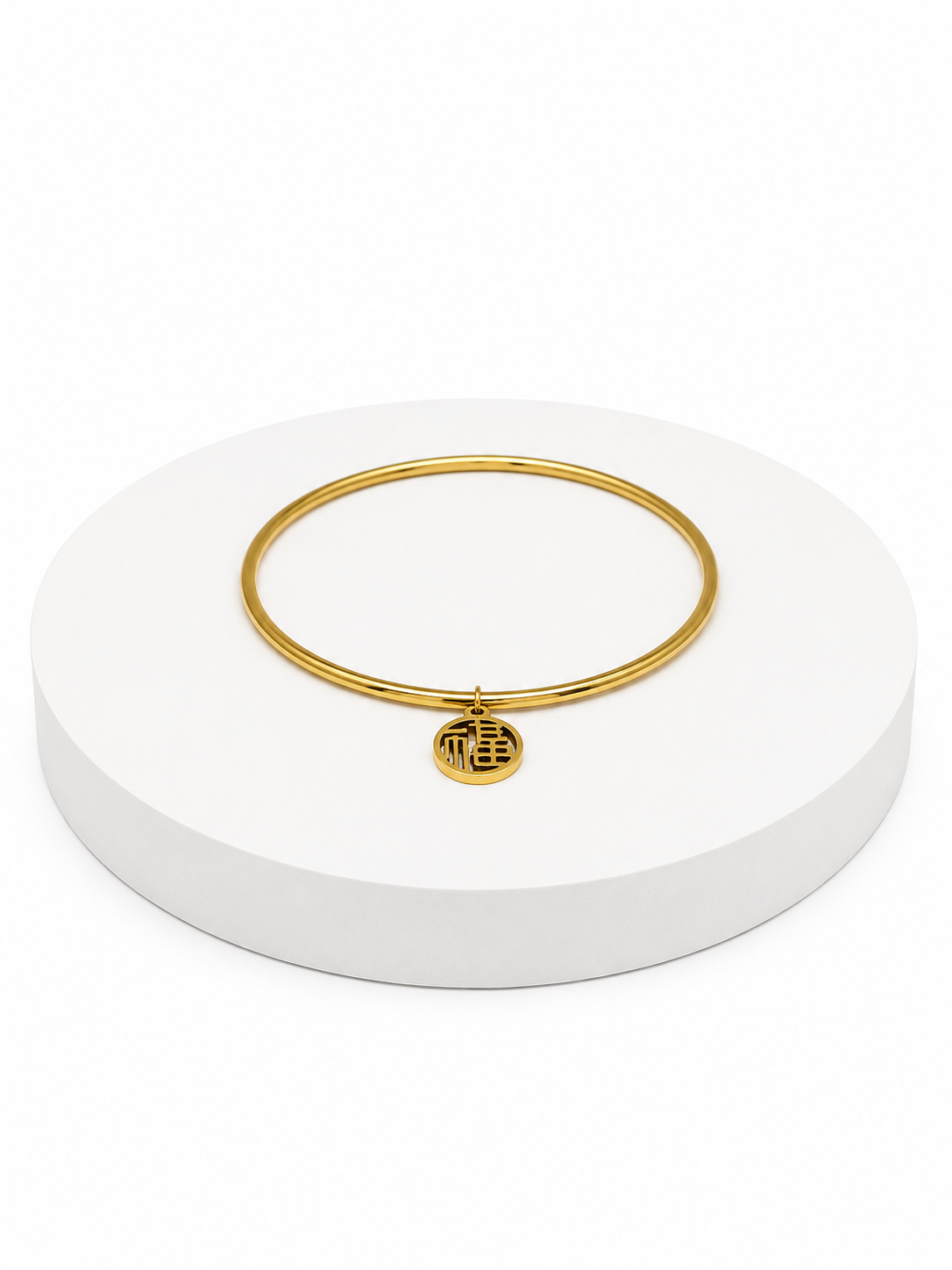Gold bracelet on a white circular stand with a white background