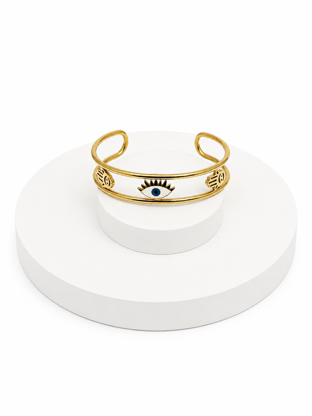 Gold bracelet with eye design on a white stand