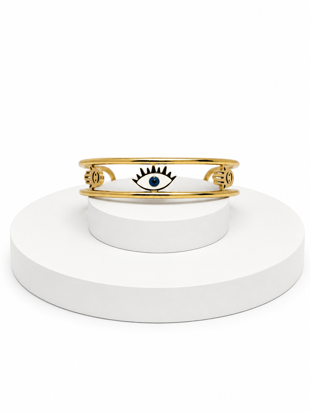 Gold bracelet with a blue gemstone on a white stand